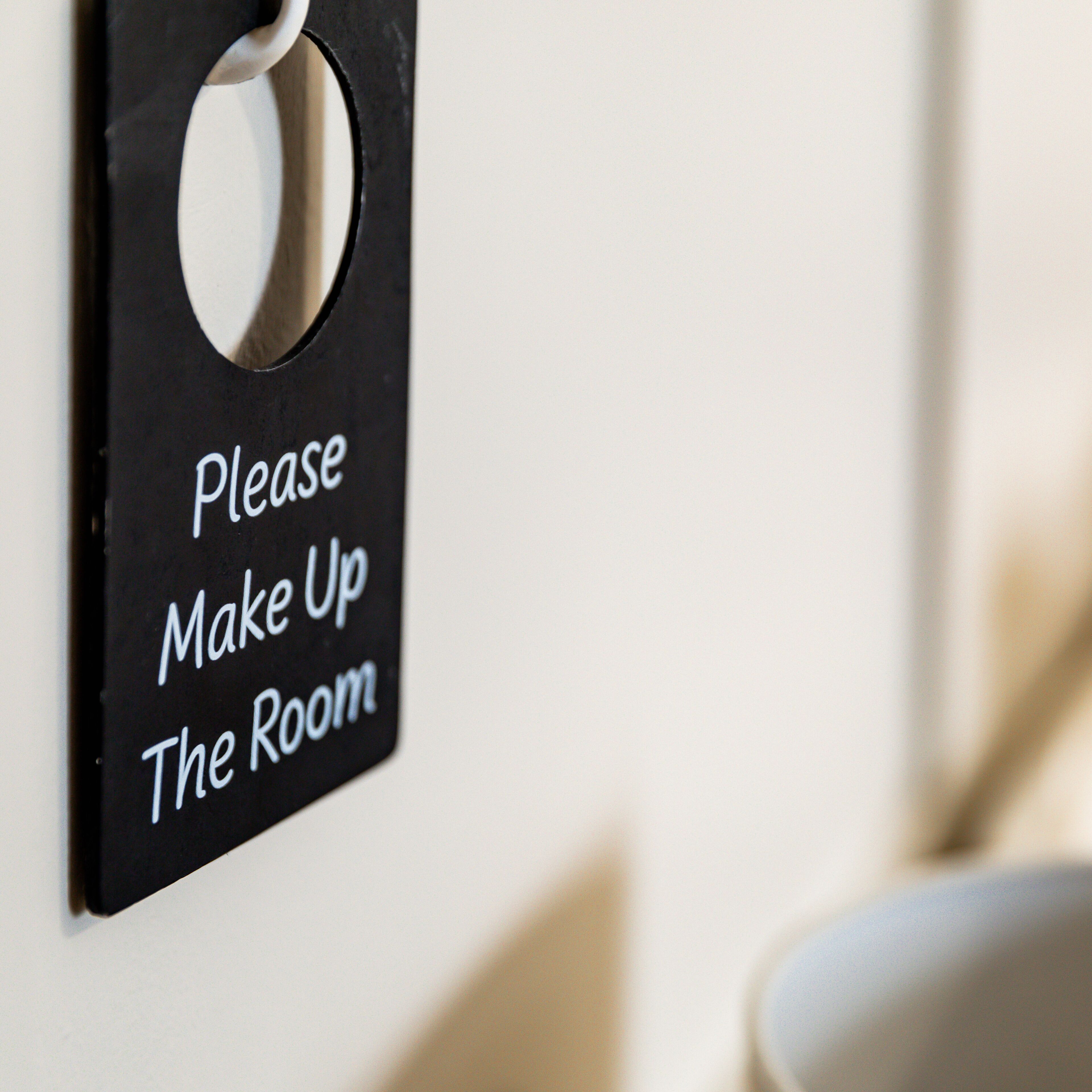 A sign on a wall that reads "Please Make Up The Room".