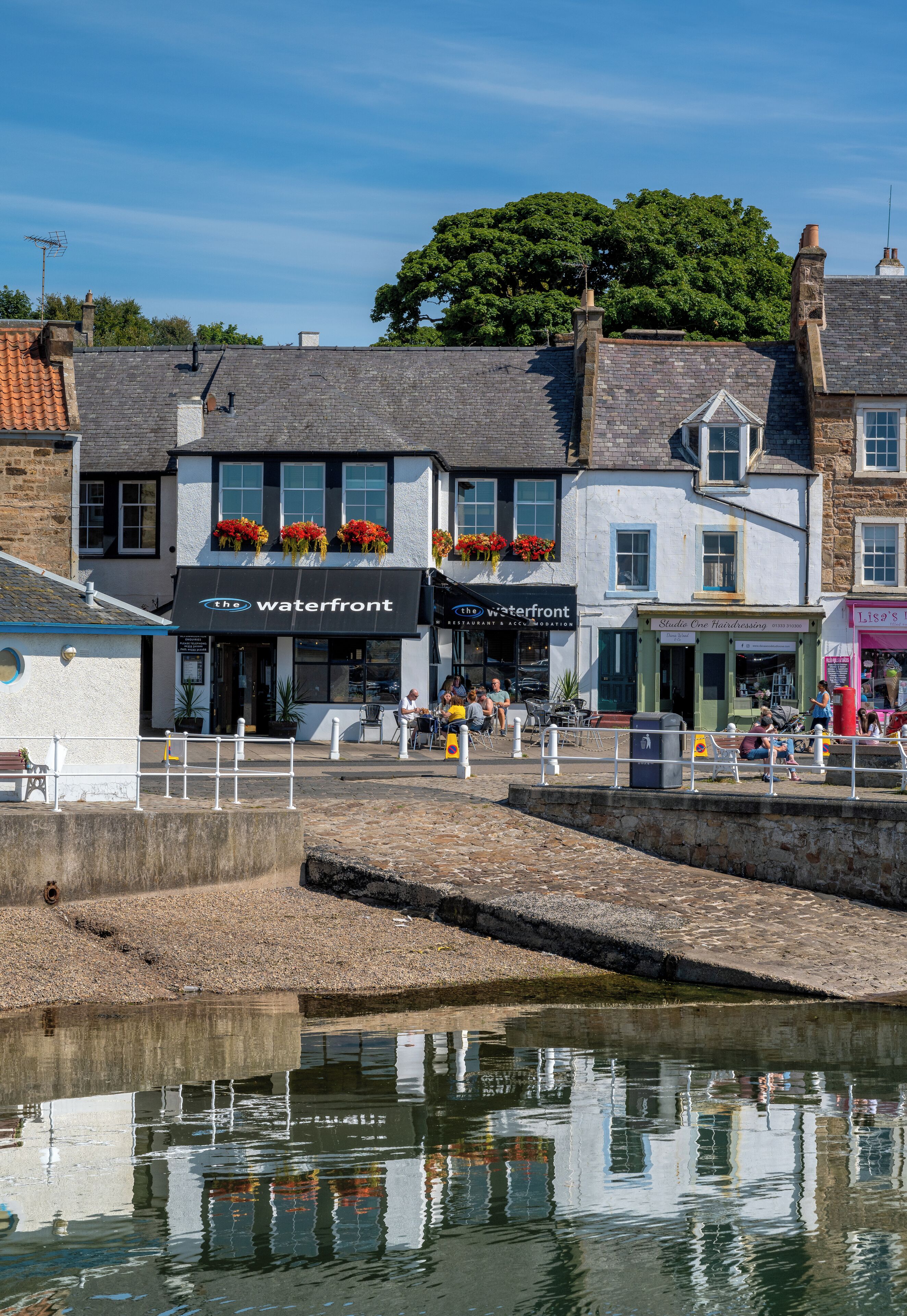 A waterfront building with a restaurant and a hairdressing salon.