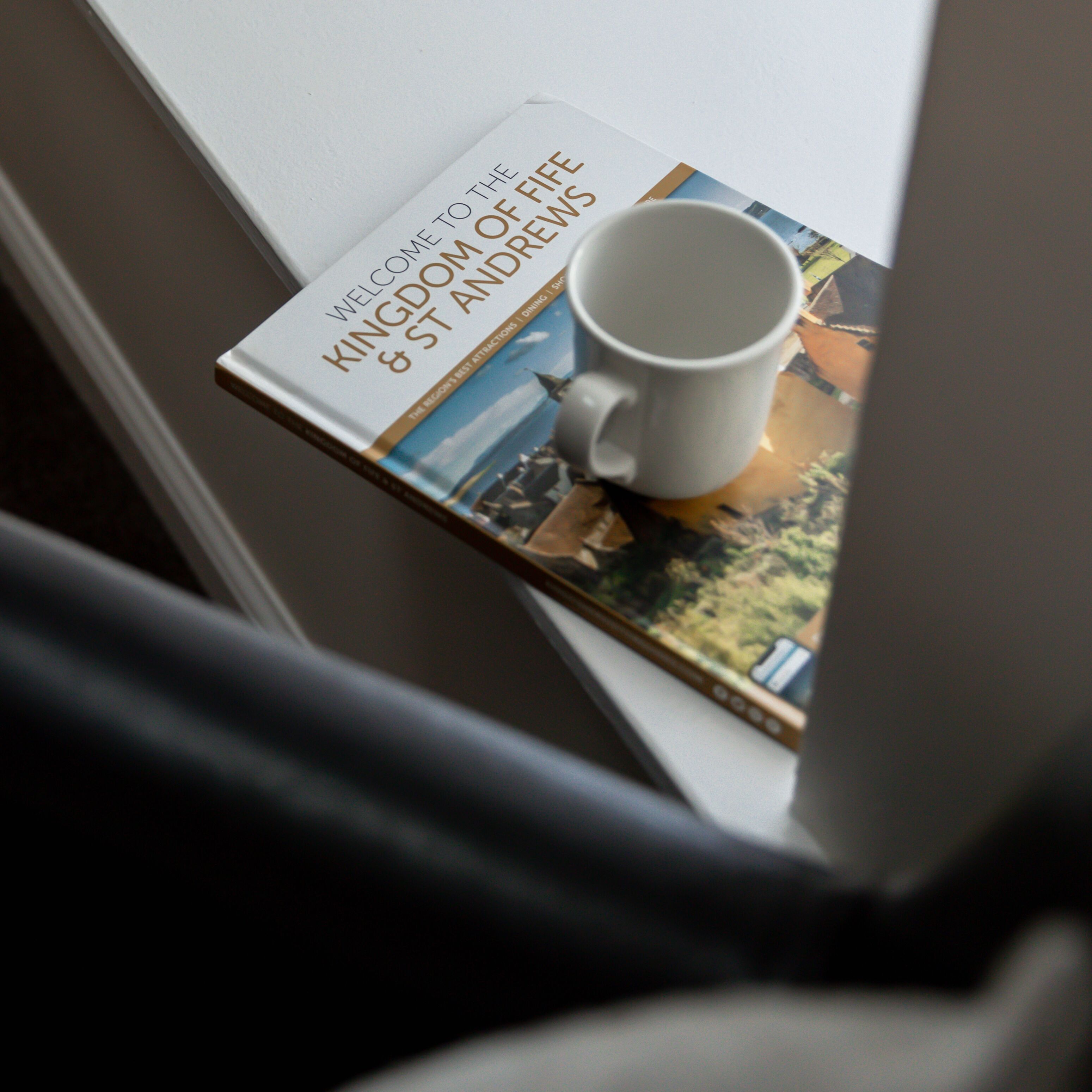 Un libro titulado “Welcome to the Kingdom of Fife & St Andrews” sobre un alféizar.