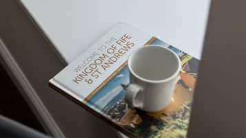 A book titled "Welcome to the Kingdom of Fife & St Andrews" placed on a windowsill.