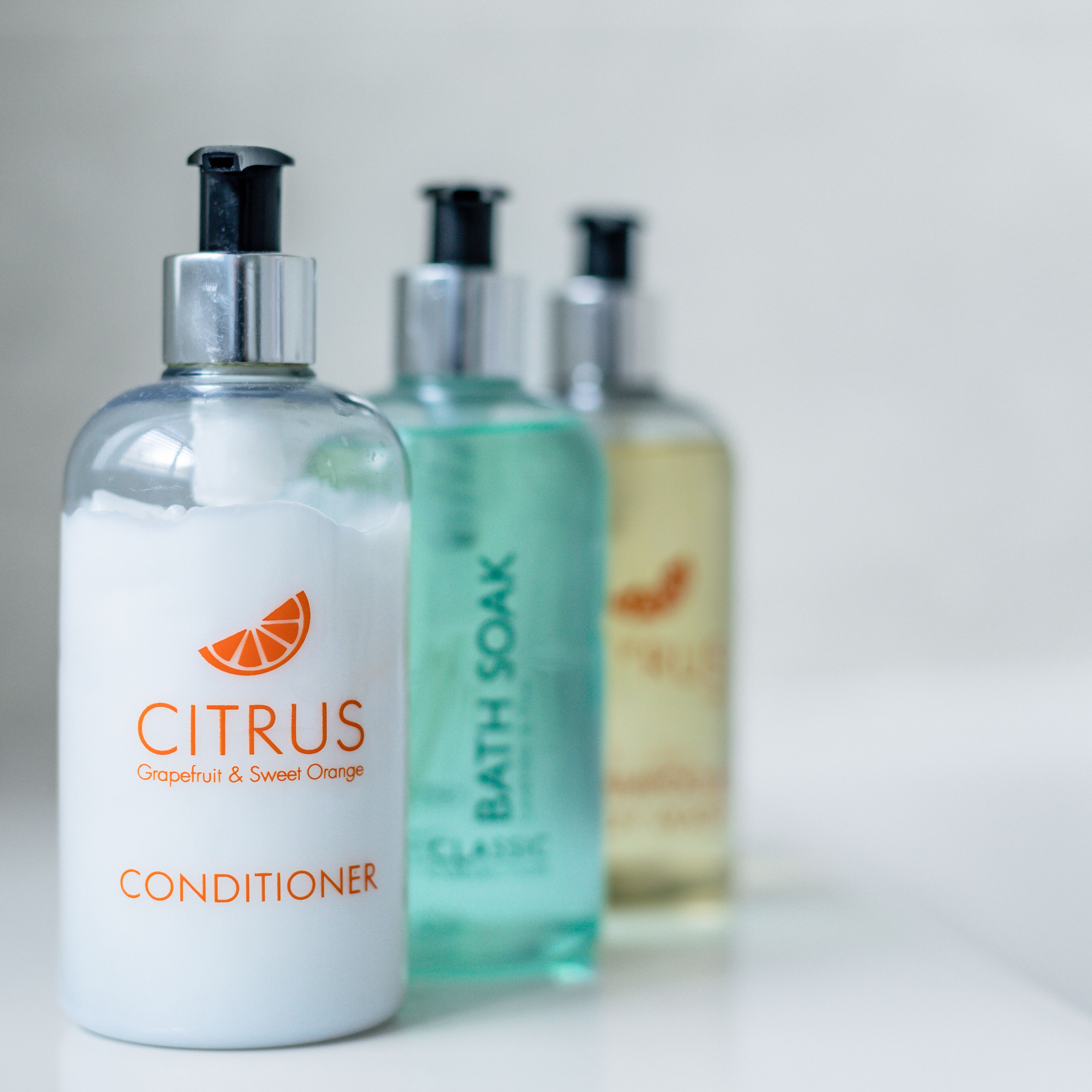Tres botellas de productos de baño con aroma cítrico.