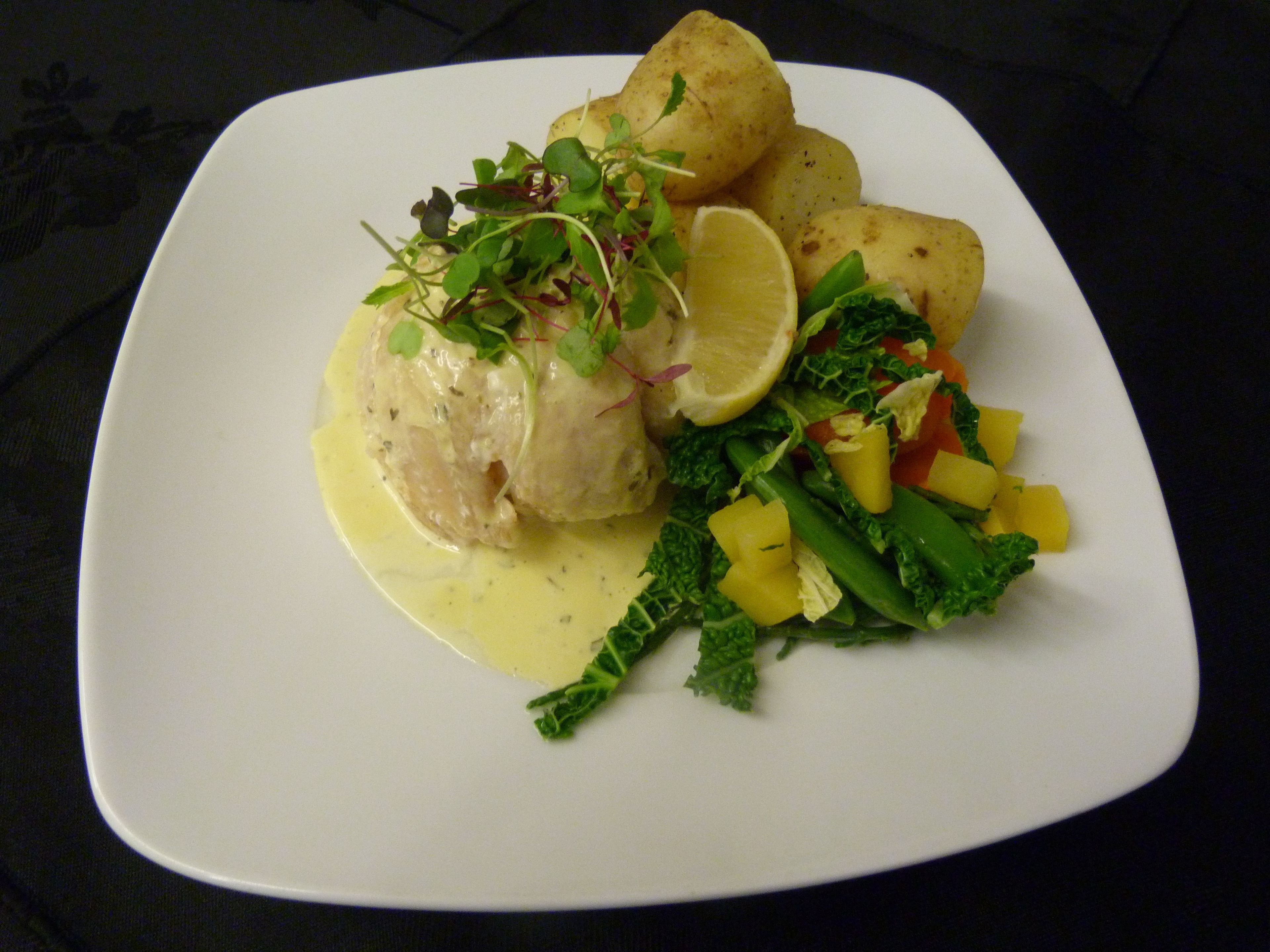 A plate of food with a piece of meat, potatoes, and vegetables.