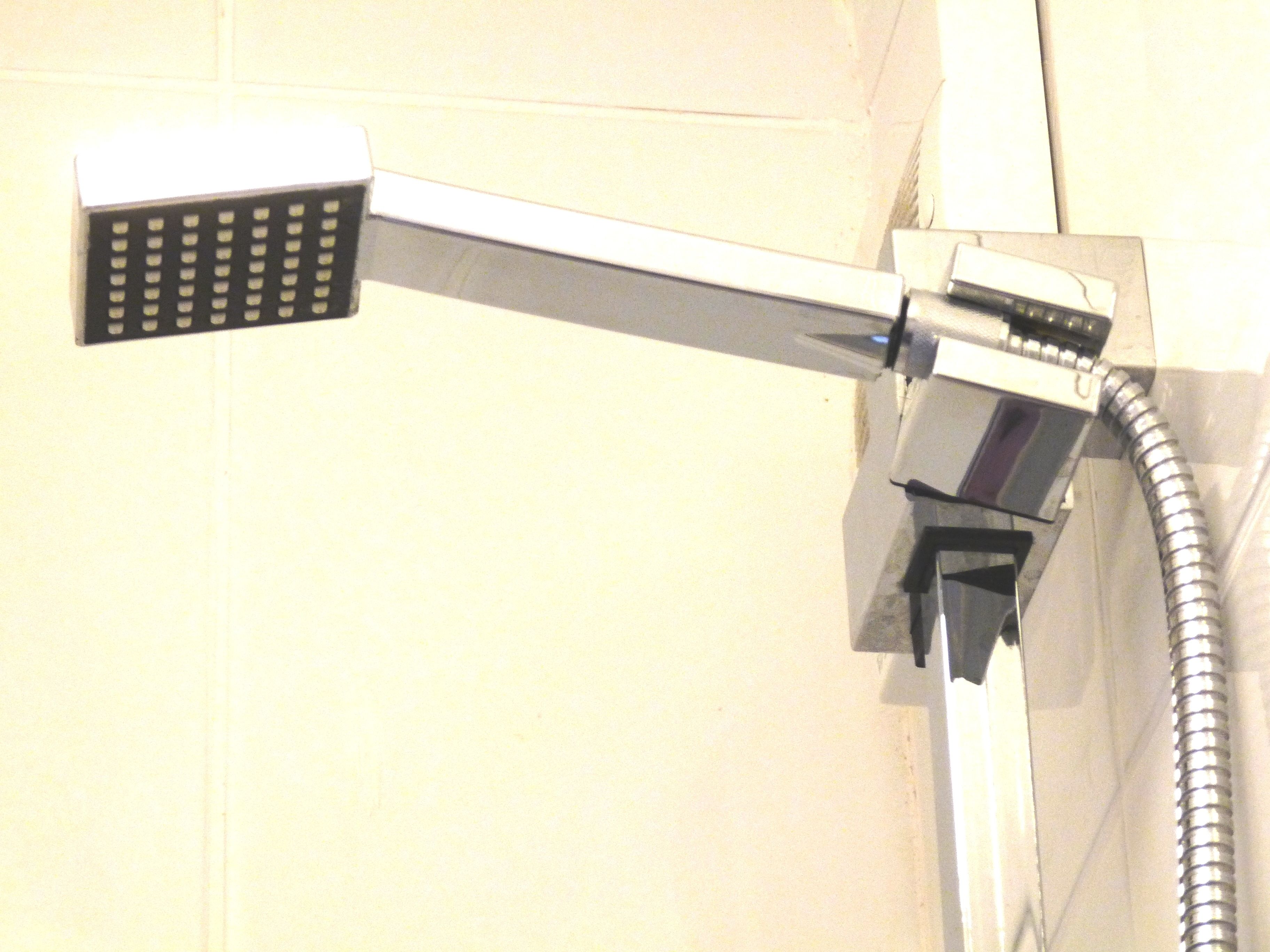 A showerhead attached to a wall.