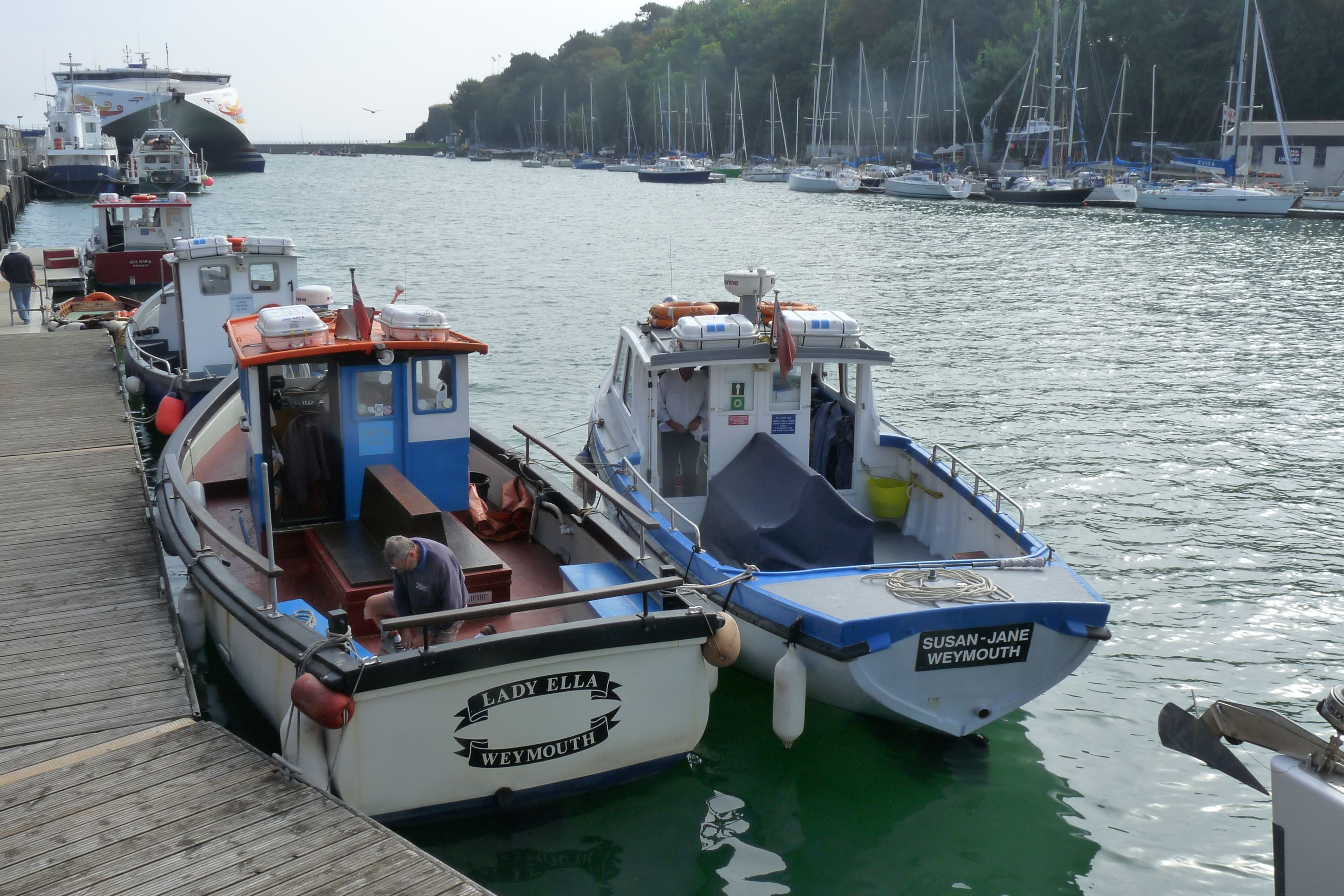 A marina with several boats docked, including a boat named 'Lady Ella Weymouth'.