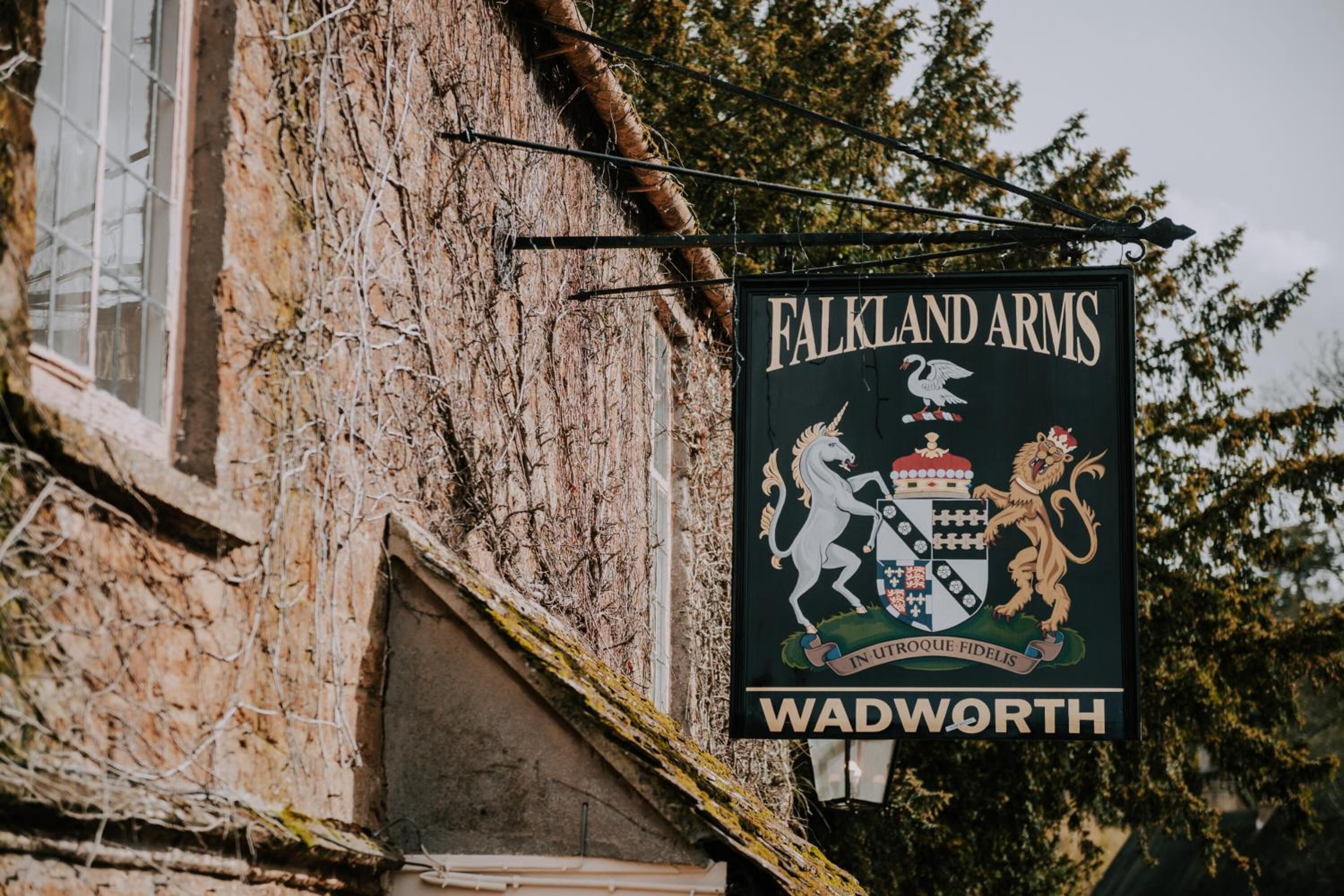 A sign for 'Falkland Arms' in Wadworth, featuring a coat of arms with a lion and a unicorn.