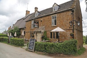 A stone building with a sign reading "FALAND ARMS" and a chalkboard sign outside.