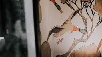 Un mur orné d’une fresque représentant un oiseau et des branches.