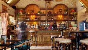 Un coin bar au style rustique, avec des meubles en bois, un comptoir et un lustre.