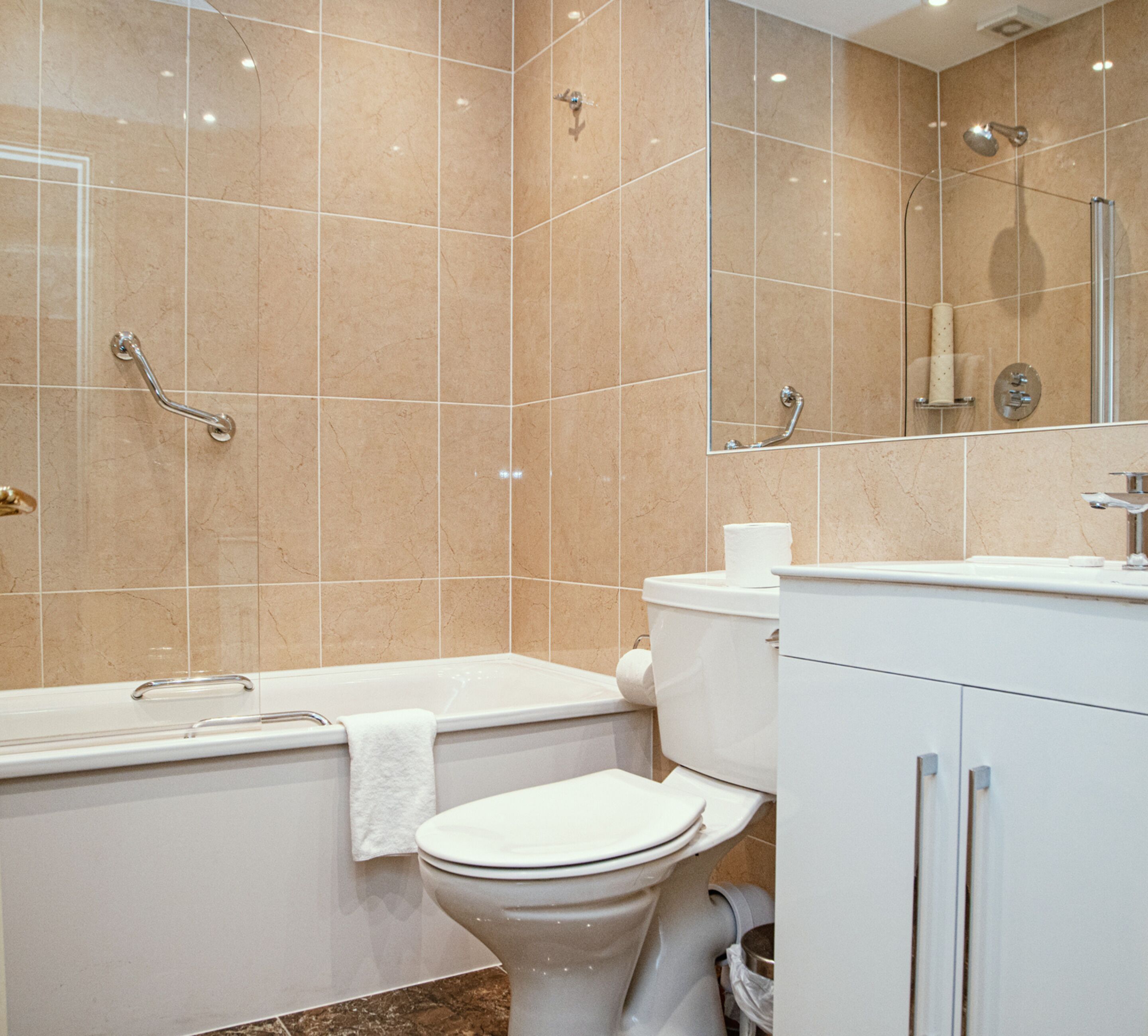 A modern bathroom with a bathtub, toilet, and a shower area.