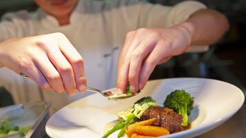 A person serving food on a white plate.