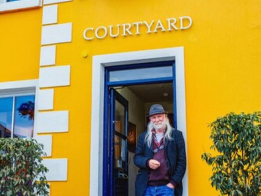 A building with a bright yellow facade and a sign that reads "COURTYARD."
