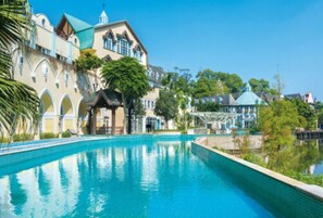 Una piscina con vista despejada a un edificio de hotel al fondo.