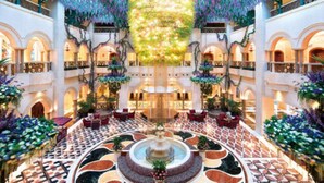 A spacious atrium with a central fountain, multiple balconies, and lush greenery. - The Interlaken OCT Hotel Shenzhen (Shenzhen)