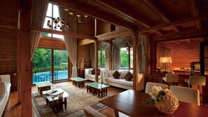 A wooden cabin interior with a dining area, sofas, and a view of the outdoors. - The Interlaken OCT Hotel Shenzhen (Shenzhen)