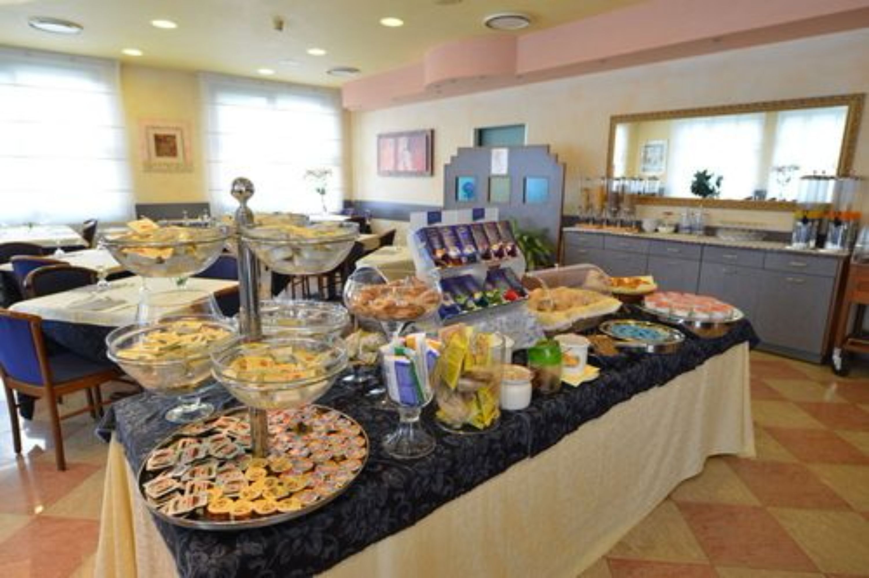 Una mesa de buffet con diferentes platillos y una cocina al fondo.