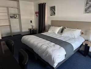 A hotel room with a bed, a desk, a chair, a wardrobe, and a nightstand. - Hotel Dupleix (Quimper)