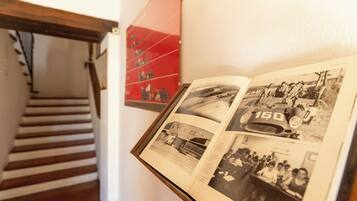 A book with black and white photos, a staircase, and a red poster on the wall.