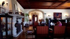 A traditional interior with a fireplace, seating area, and a hallway leading to another room. - Boega Hotel (Vila Nova de Cerveira)