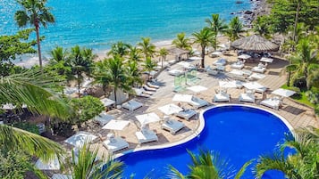 Una piscina techada, una piscina al aire libre, sombrillas
