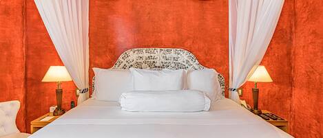 A bed with white linens, a zebra-patterned headboard, and white curtains.