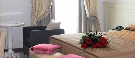 Una habitación de hotel con cama, escritorio, silla y una pequeña mesa.