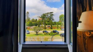 Een uitzicht op een parkeerplaats en bomen vanuit een raam.