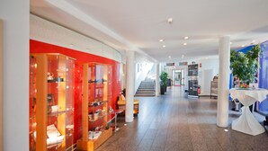 A modern hotel lobby with a red and white color scheme, a staircase, and a reception area. - Hotel Am Froschbächel (Bühl)