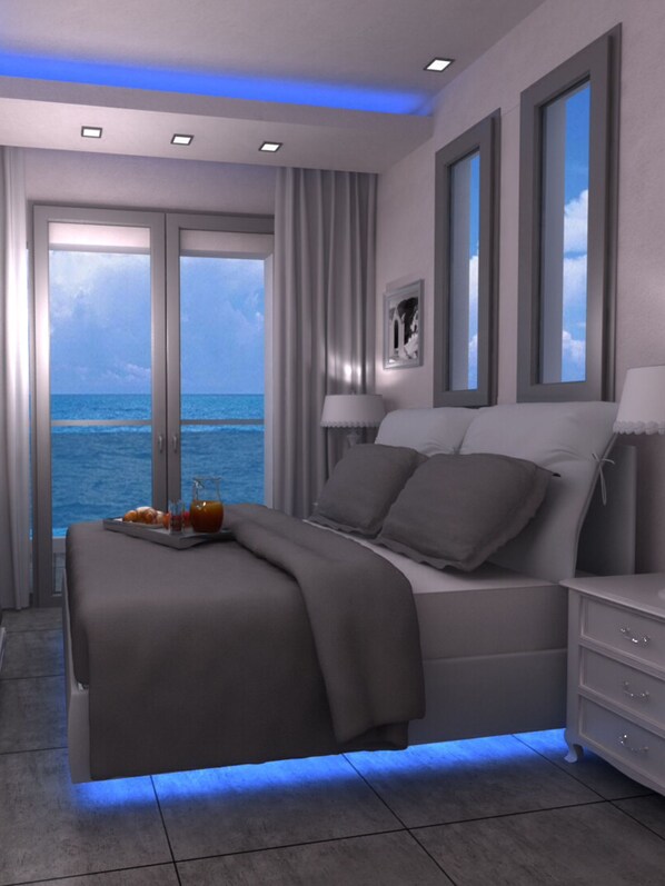 Un dormitorio moderno con cama, mesitas de noche y vista al océano.