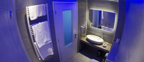 Un baño moderno con bañera, lavamanos y espejo.