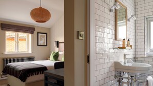 Une chambre à coucher avec un lit, une table de chevet et une fenêtre donnant sur un mur de briques.