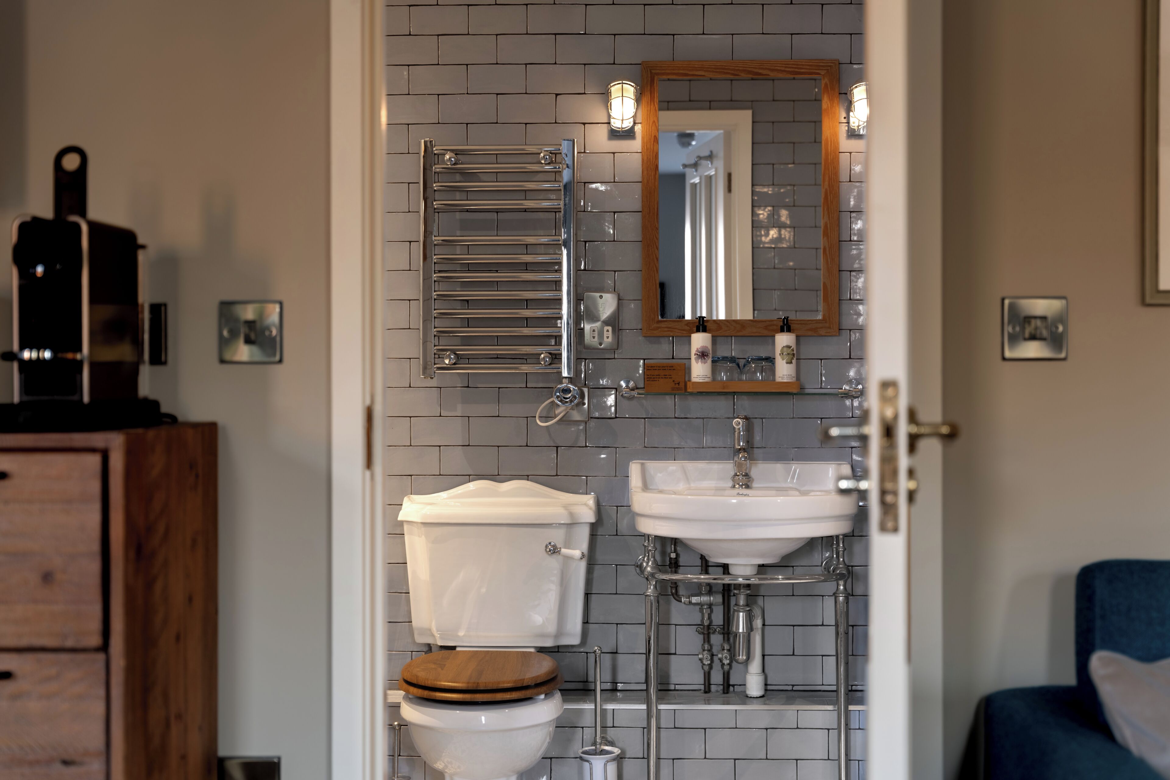 A bathroom with a toilet, sink, and mirror.