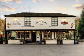 A pub with 'The White Hart Inn' signage, outdoor seating, and potted plants. - The White Hart (Stockbridge)