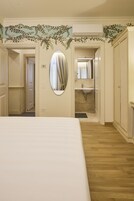 Una camera da letto con un letto, un bagno con un lavandino e uno specchio.
