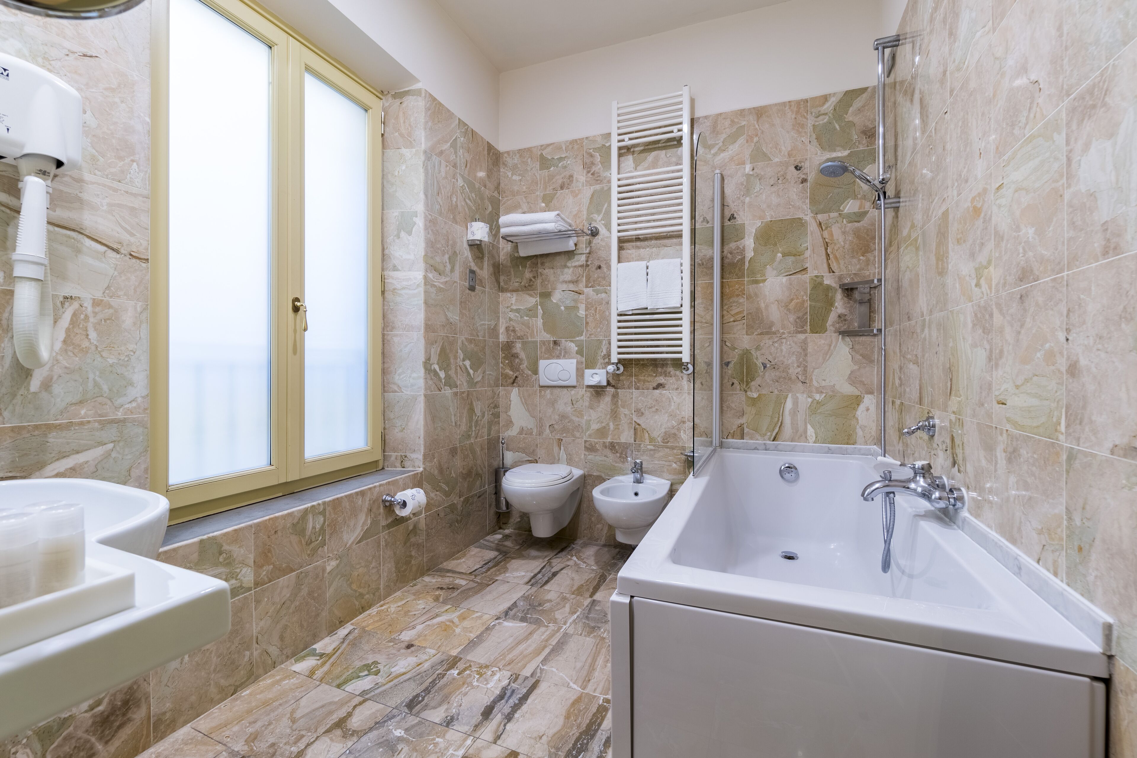 designer toiletries, hair dryer, slippers, bidet