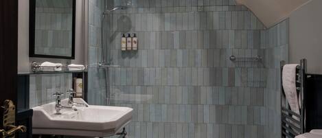 A modern bathroom with a glass shower enclosure, a white sink, and a black toilet.
