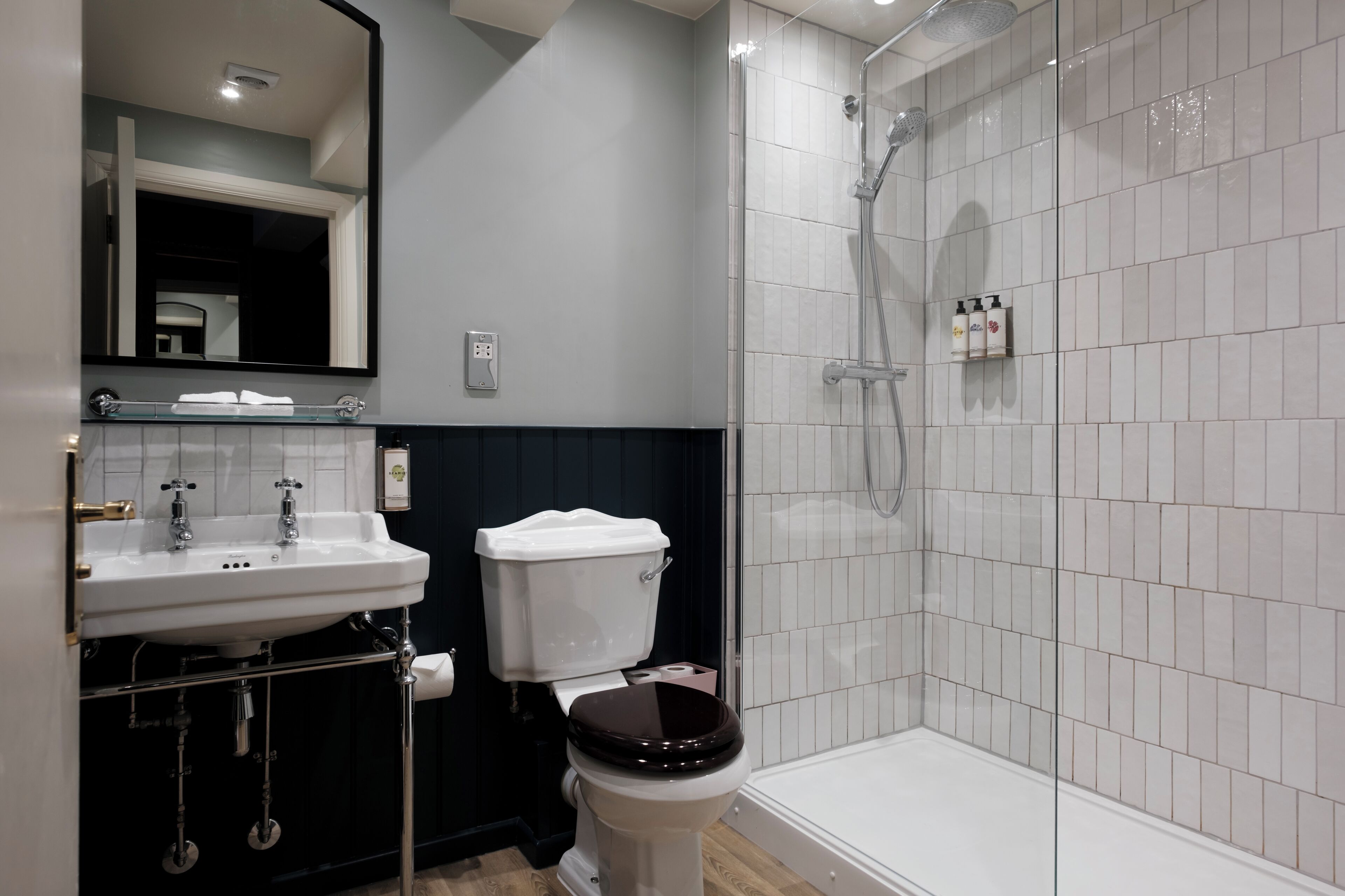 Ein modernes Badezimmer mit einem weißen Waschbecken, einer Toilette und einer gläsernen Duschkabine.