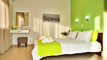 Habitación de hotel con cama, mesita de noche, espejo, pintura y pared verde.