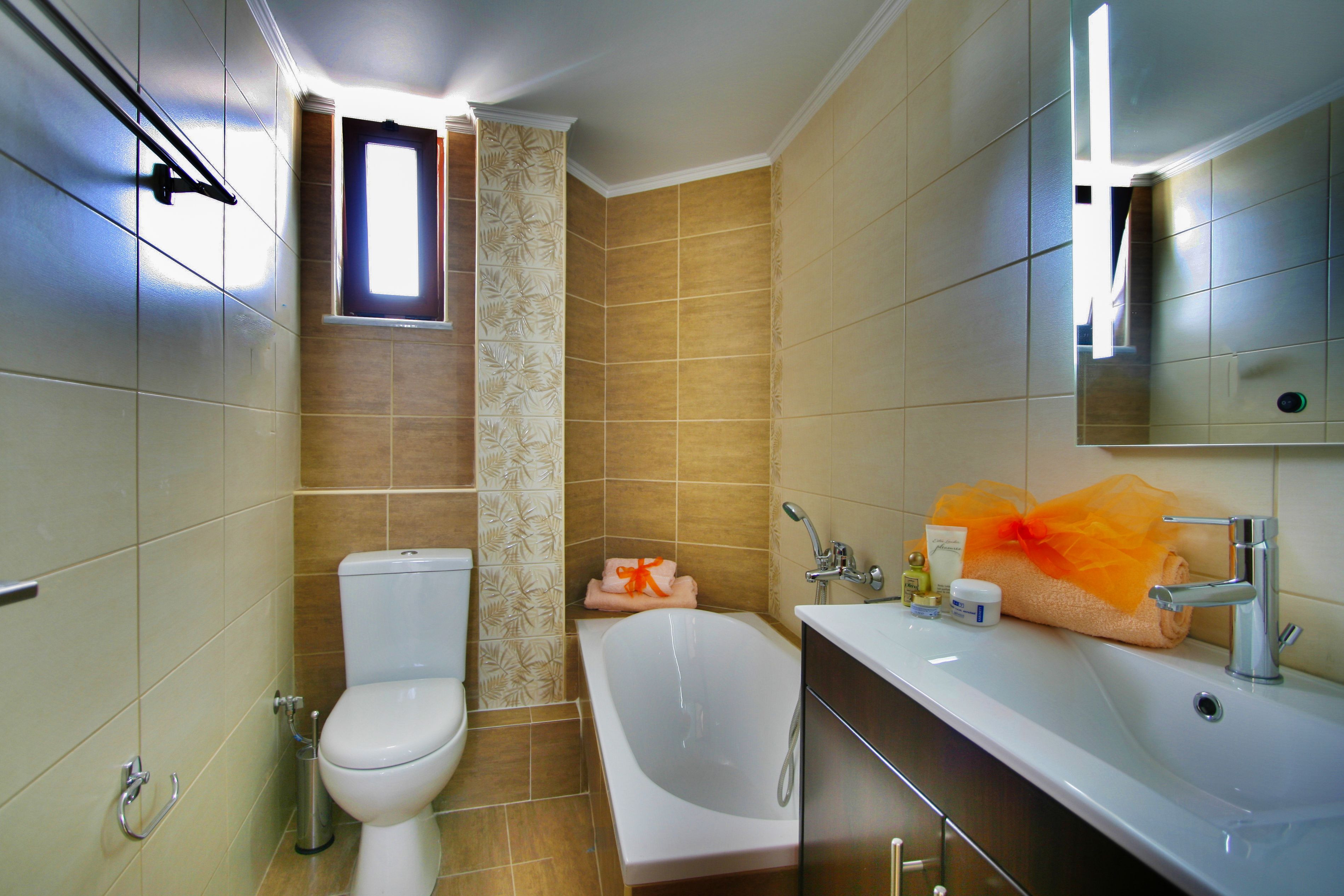 A bathroom with a toilet, bathtub, and sink.