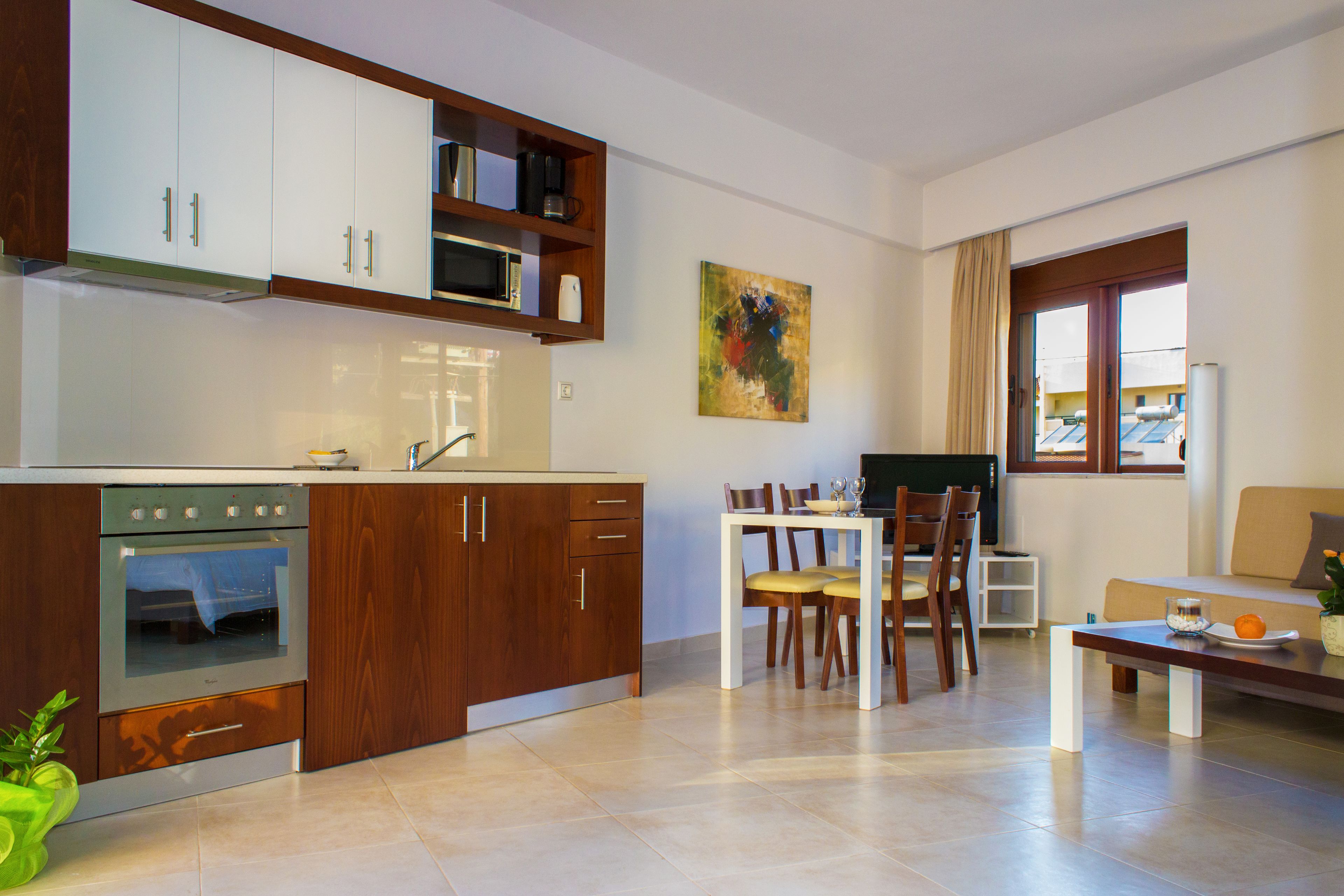 Eine moderne Küche mit Holzausbau, einem eingebauten Backofen und einem Essbereich mit Tisch und Stühlen.