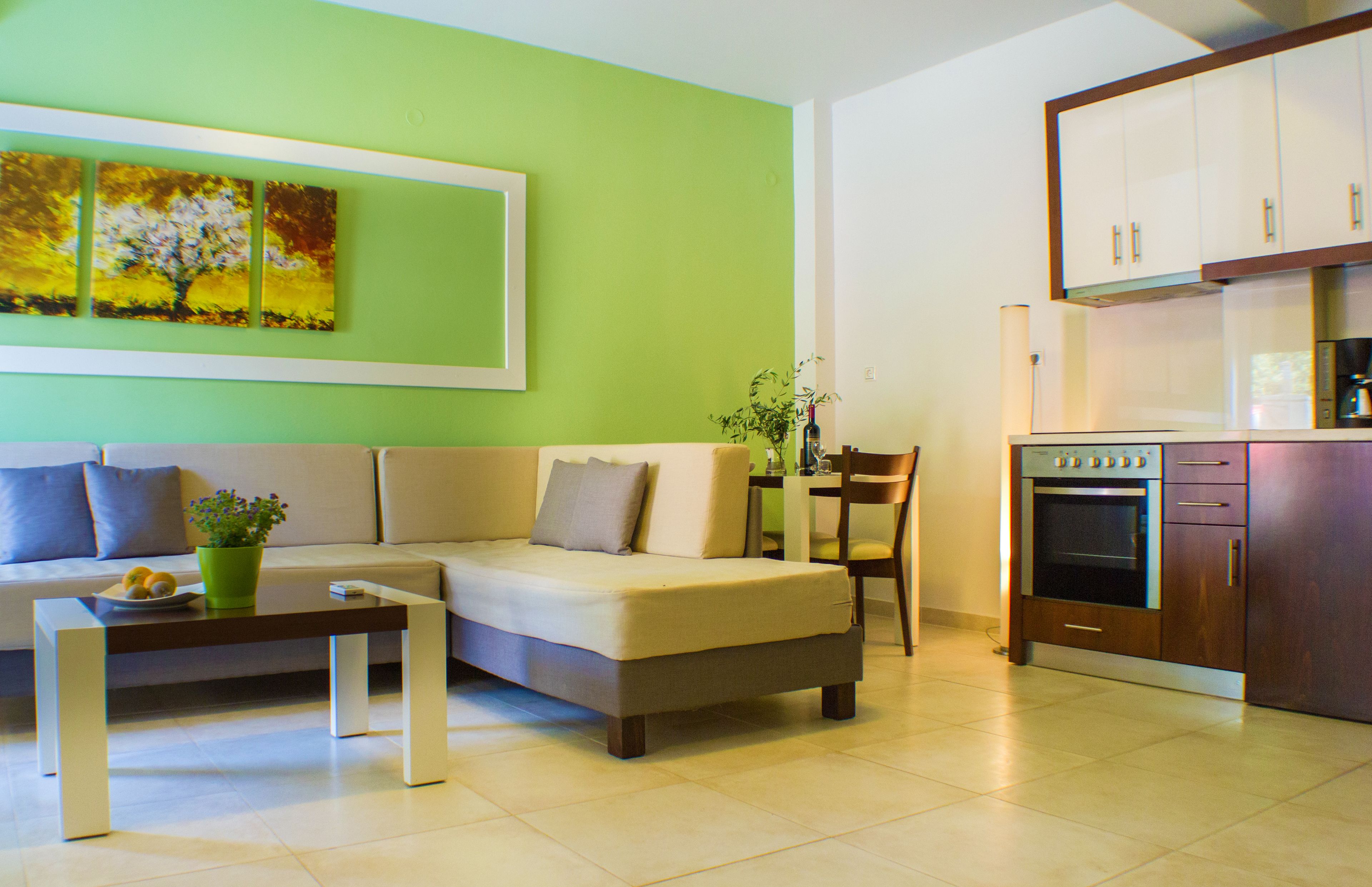 A modern living room with a sofa, a coffee table, and a dining area with a chair and table.