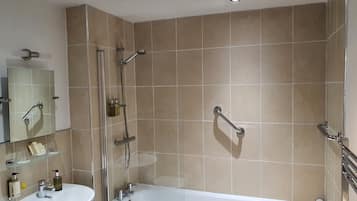 Un baño con bañera, lavamanos y cabina de ducha de vidrio.