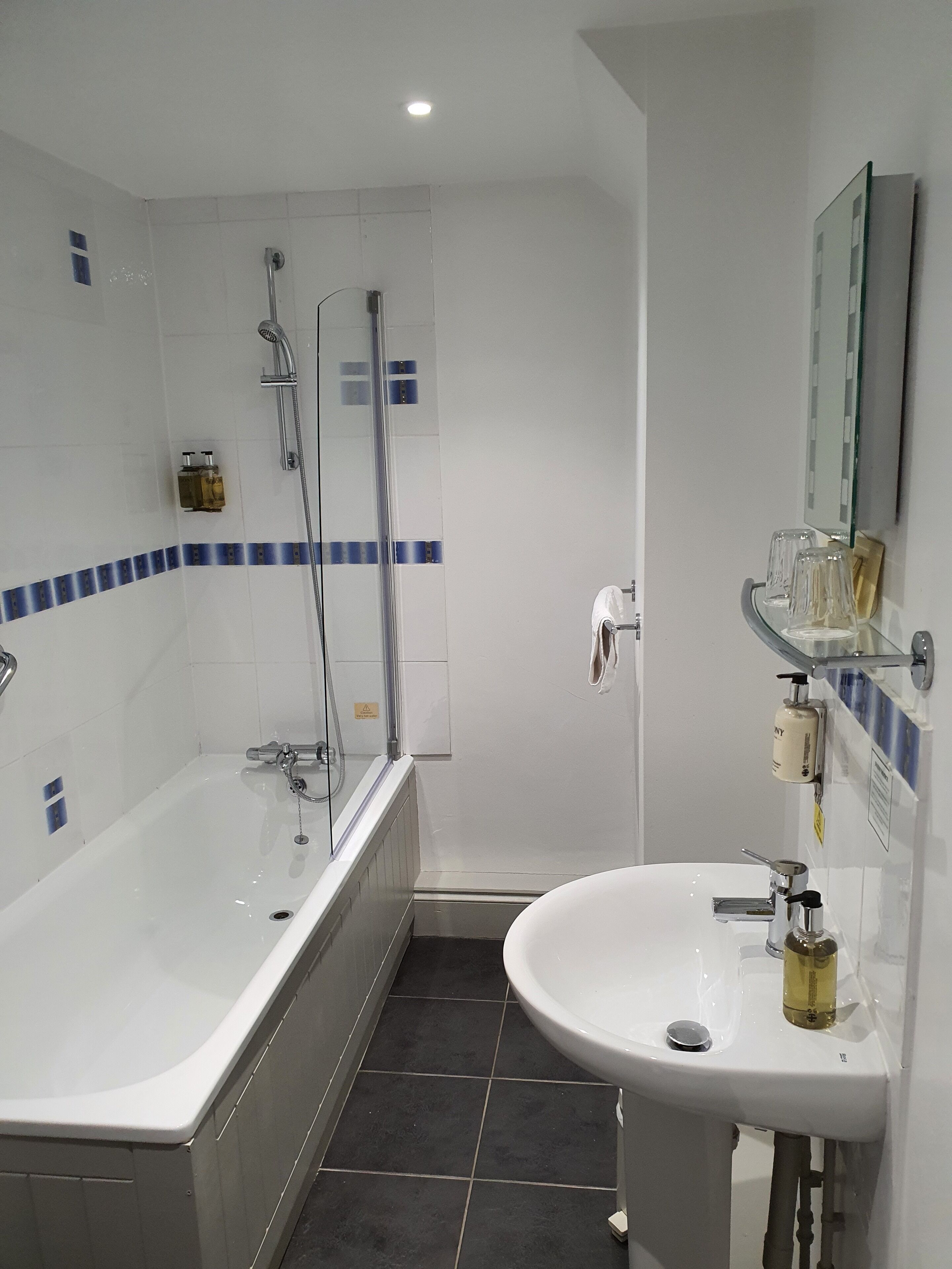 A modern bathroom with a bathtub, a sink, and a shower.