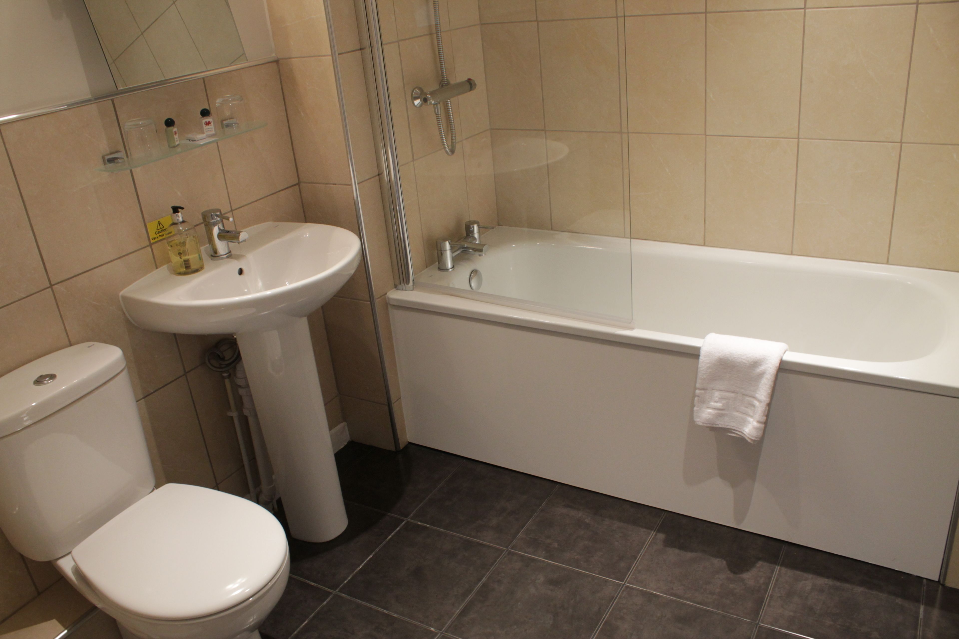 A bathroom with a toilet, sink, and bathtub.