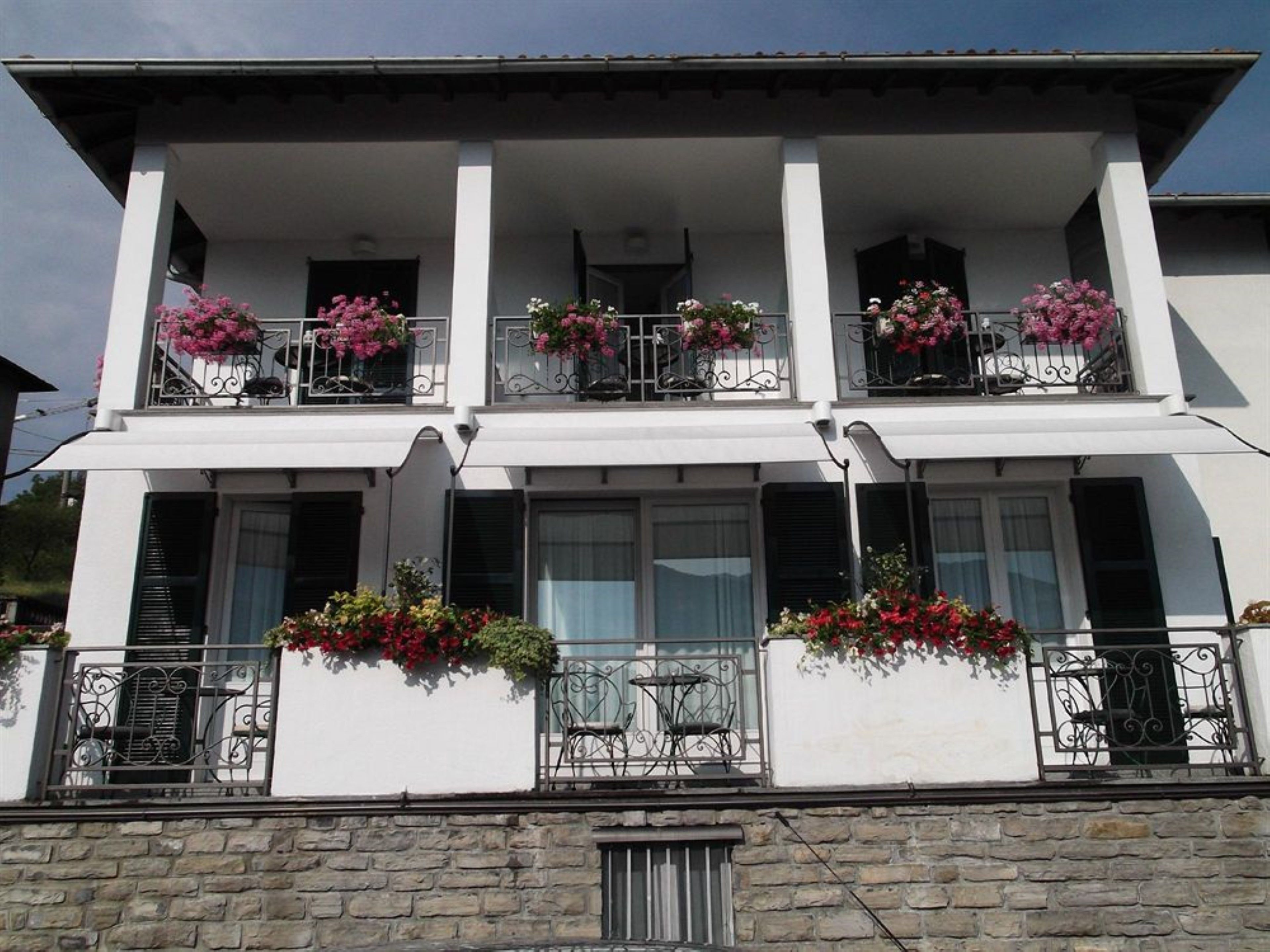 Ein zweistöckiges Gebäude mit Balkonen, jeweils mit Metallgeländern und Blumenkästen.
