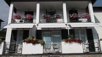 Ein zweistöckiges Gebäude mit Balkonen, jeweils mit Metallgeländern und Blumenkästen.
