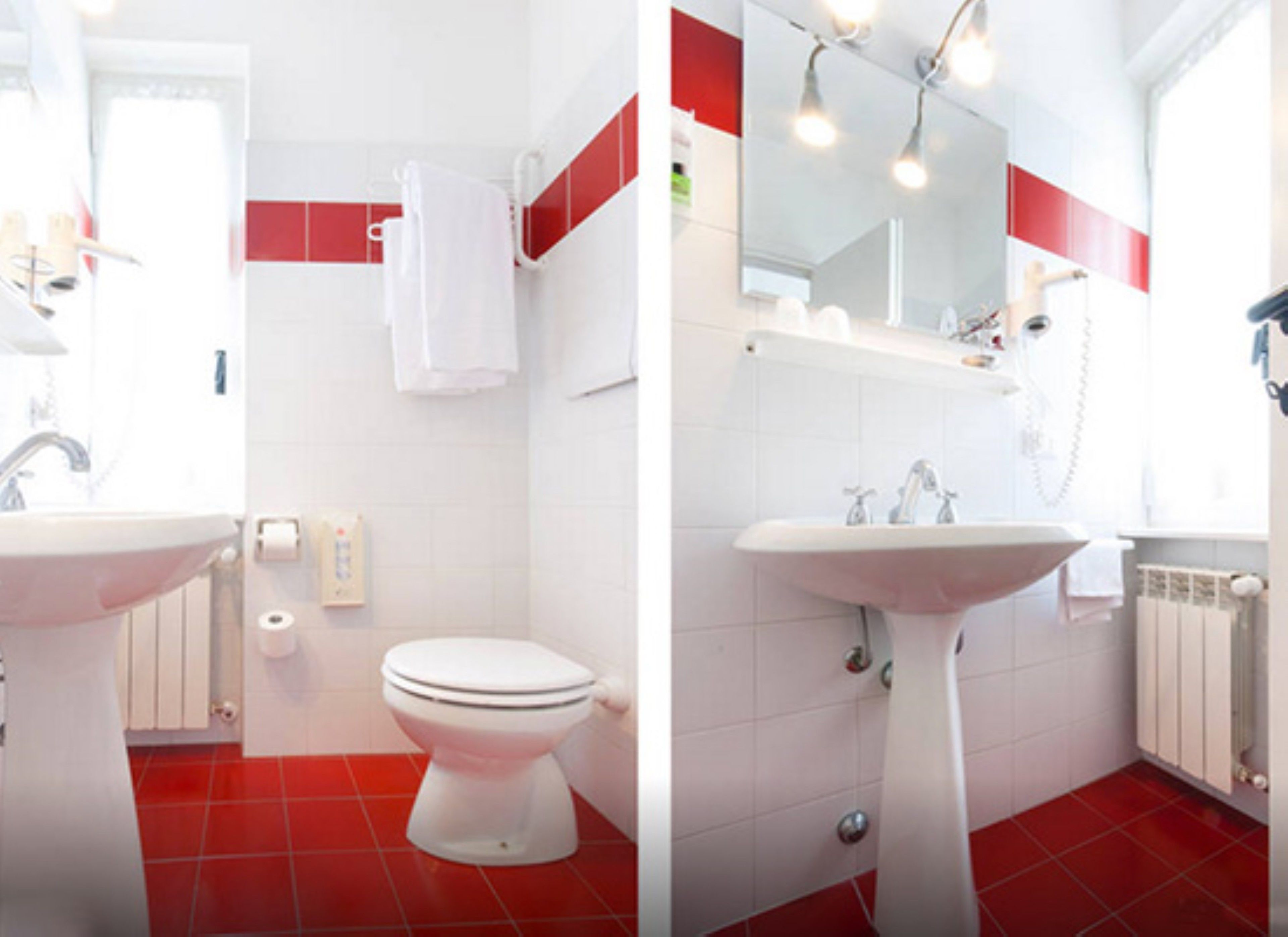 Un baño con lavamanos blanco, inodoro y suelo de baldosas rojas.