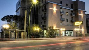 Un hotel de varios pisos con un diseño moderno, que cuenta con balcones y una fachada bien iluminada.