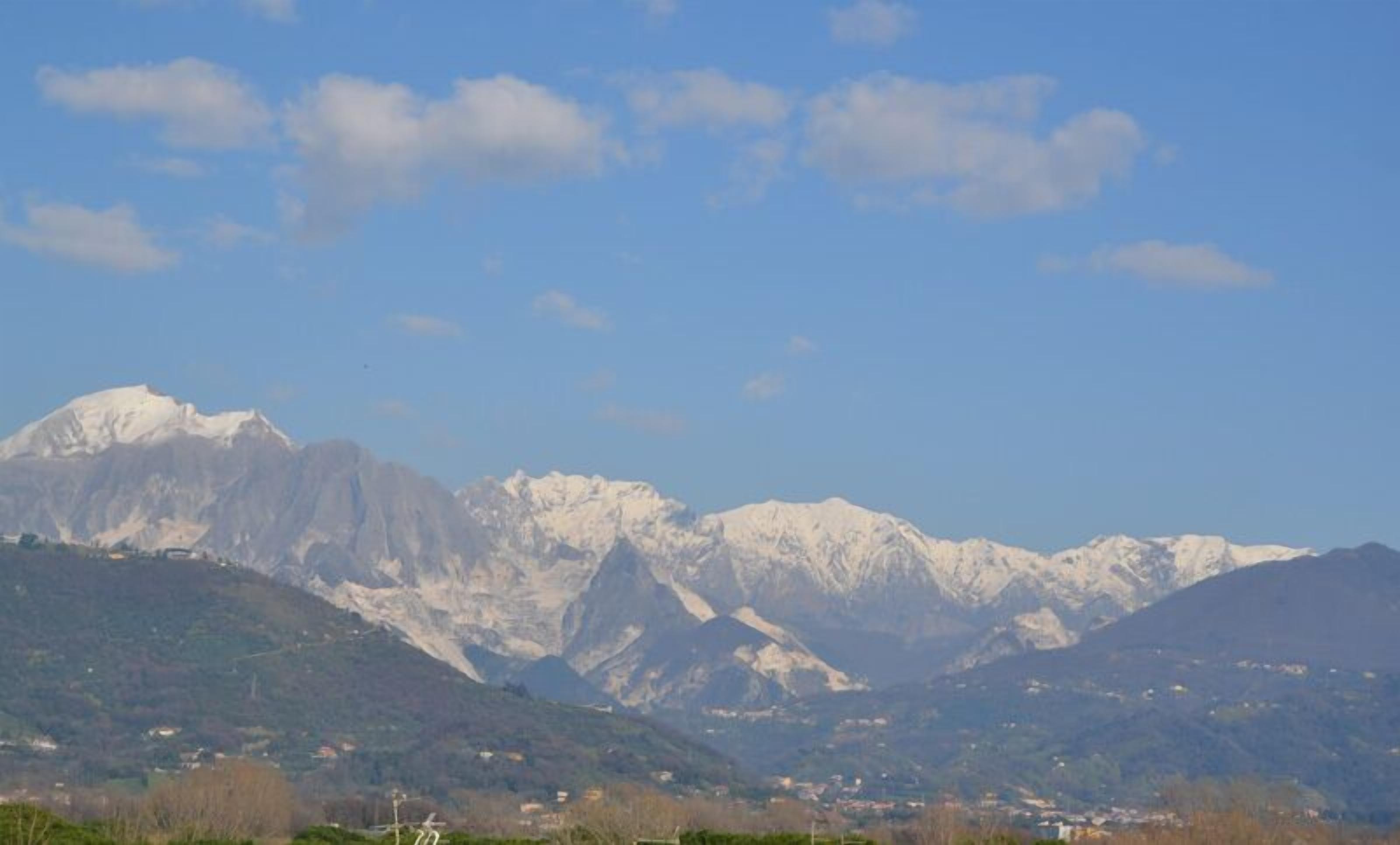 A mountain range with snow-capped peaks and a clear blue sky.