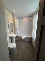 Un baño con inodoro, lavamanos y bañera.