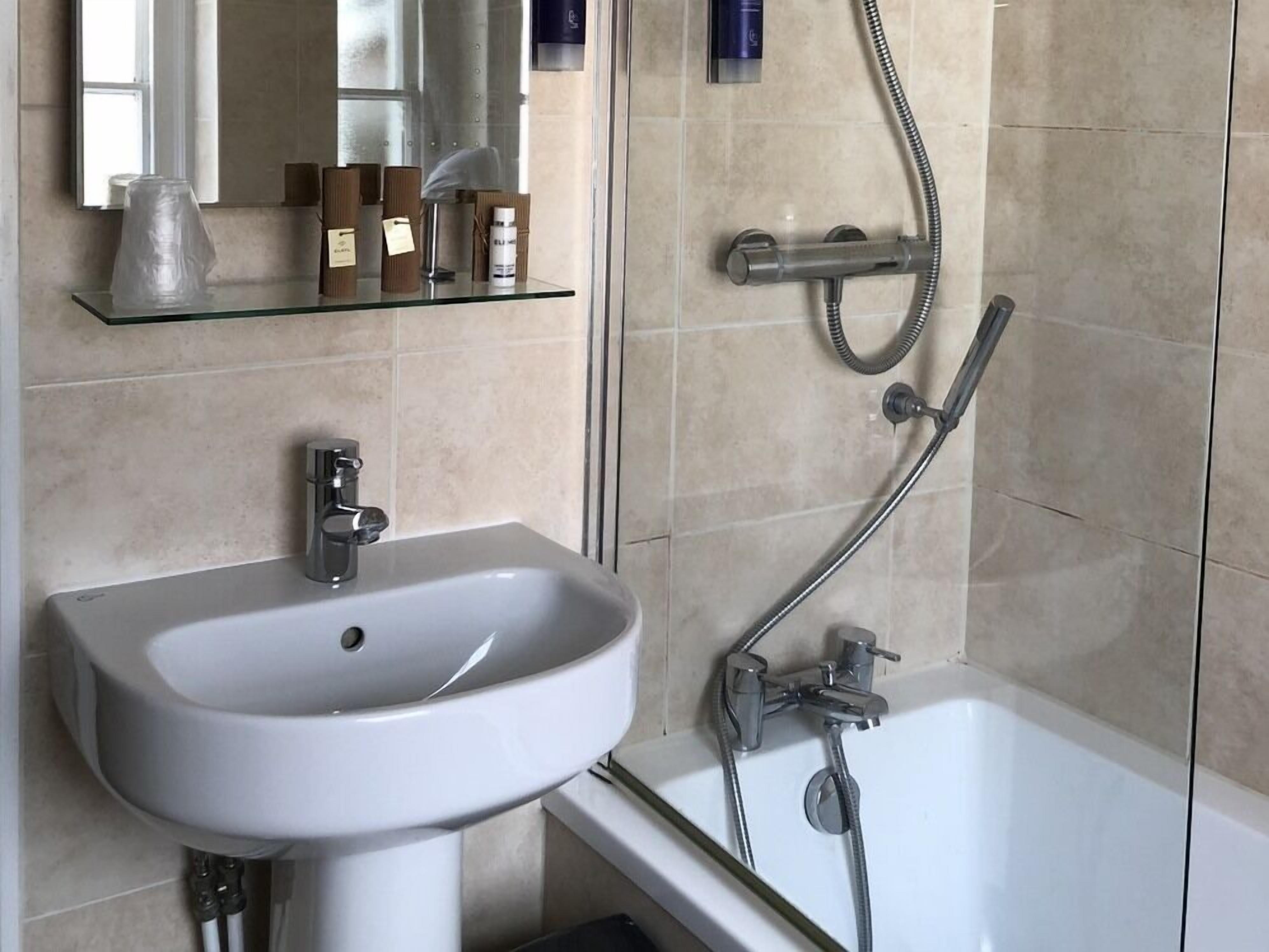 A bathroom with a white sink, a bathtub, and a shower.